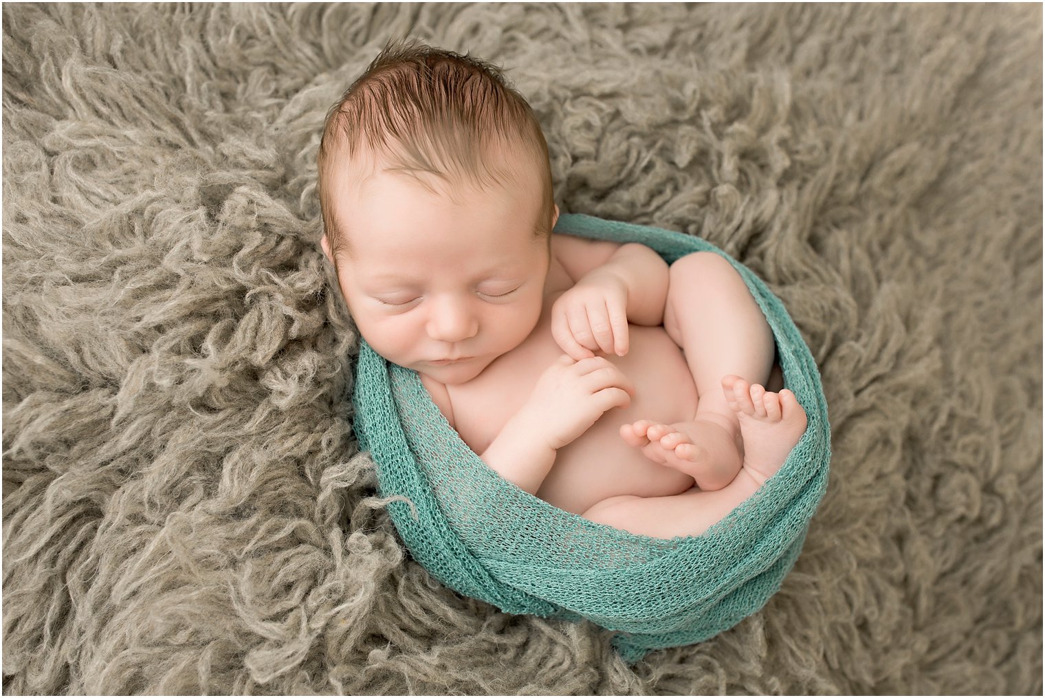 Newborn boy in gray and turquoise wrap | Photo by Idalia Photography