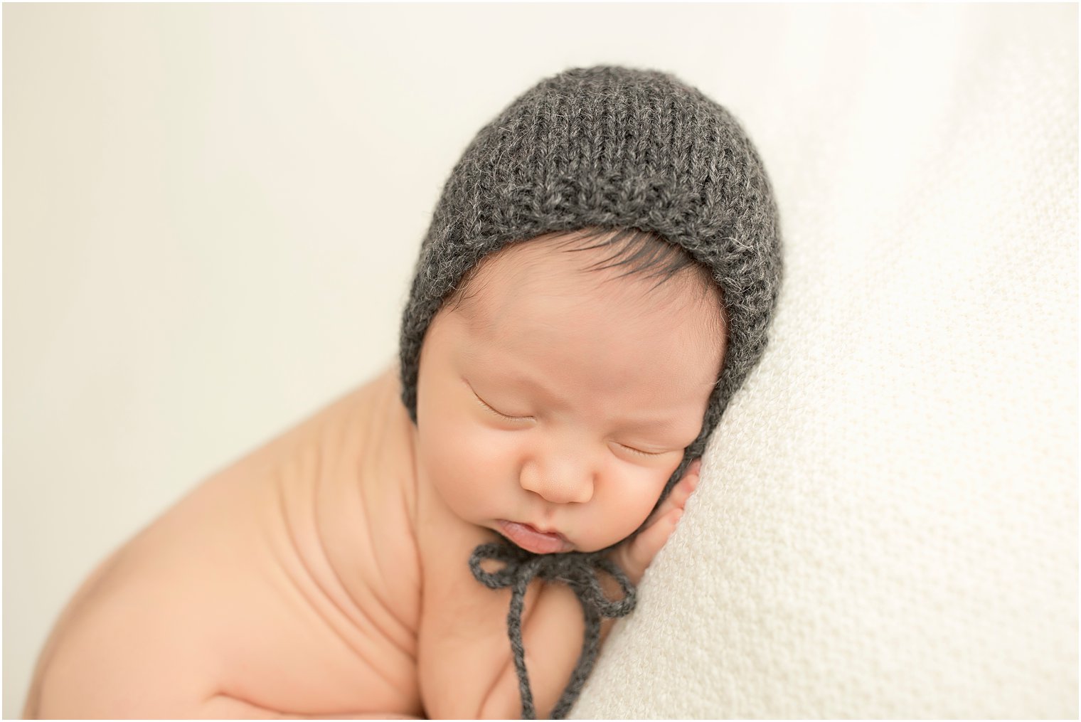 Sleepy baby boy in gray hat | Photo by Idalia Photography