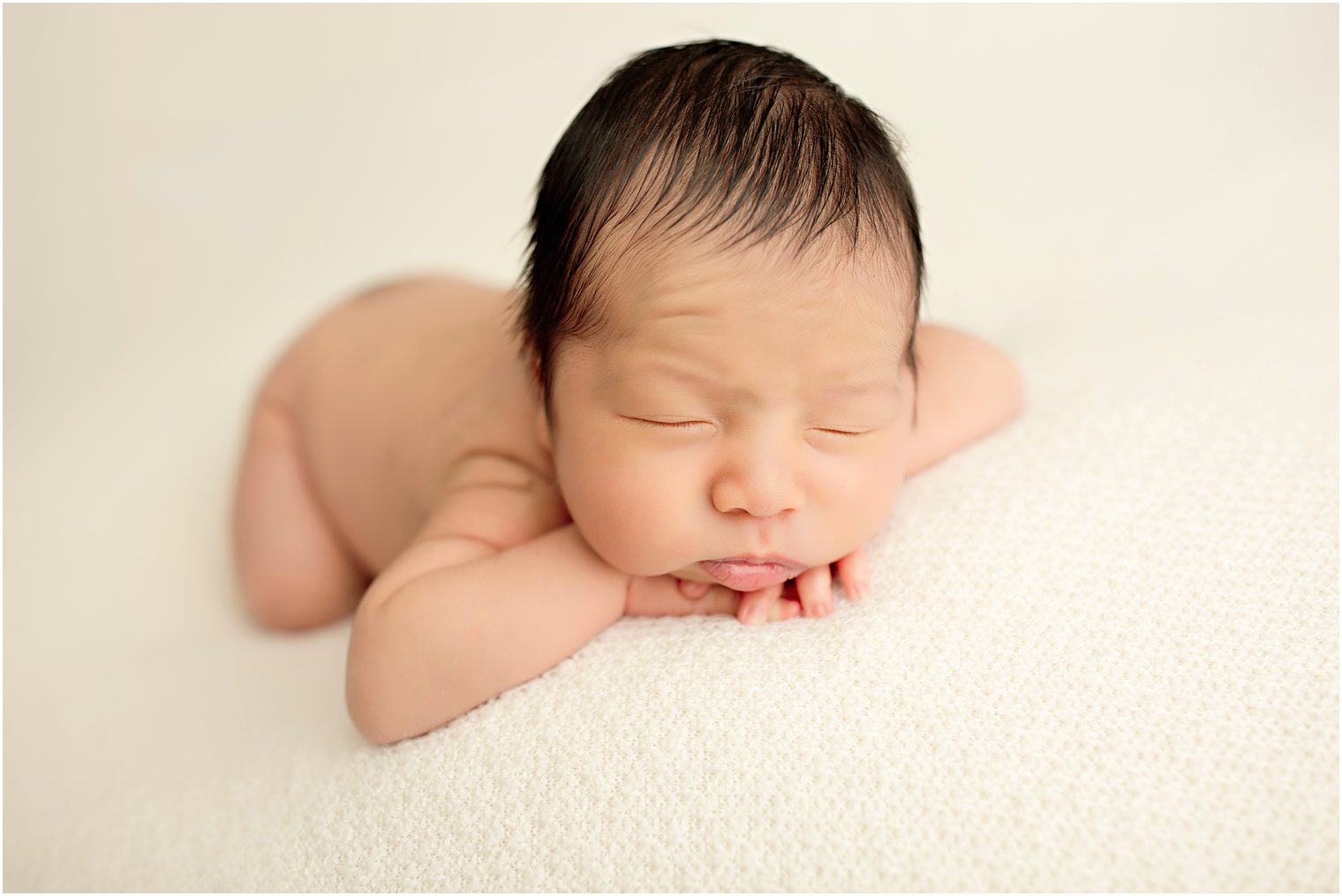 Newborn boy in chin on hands pose | Photo by Idalia Photography