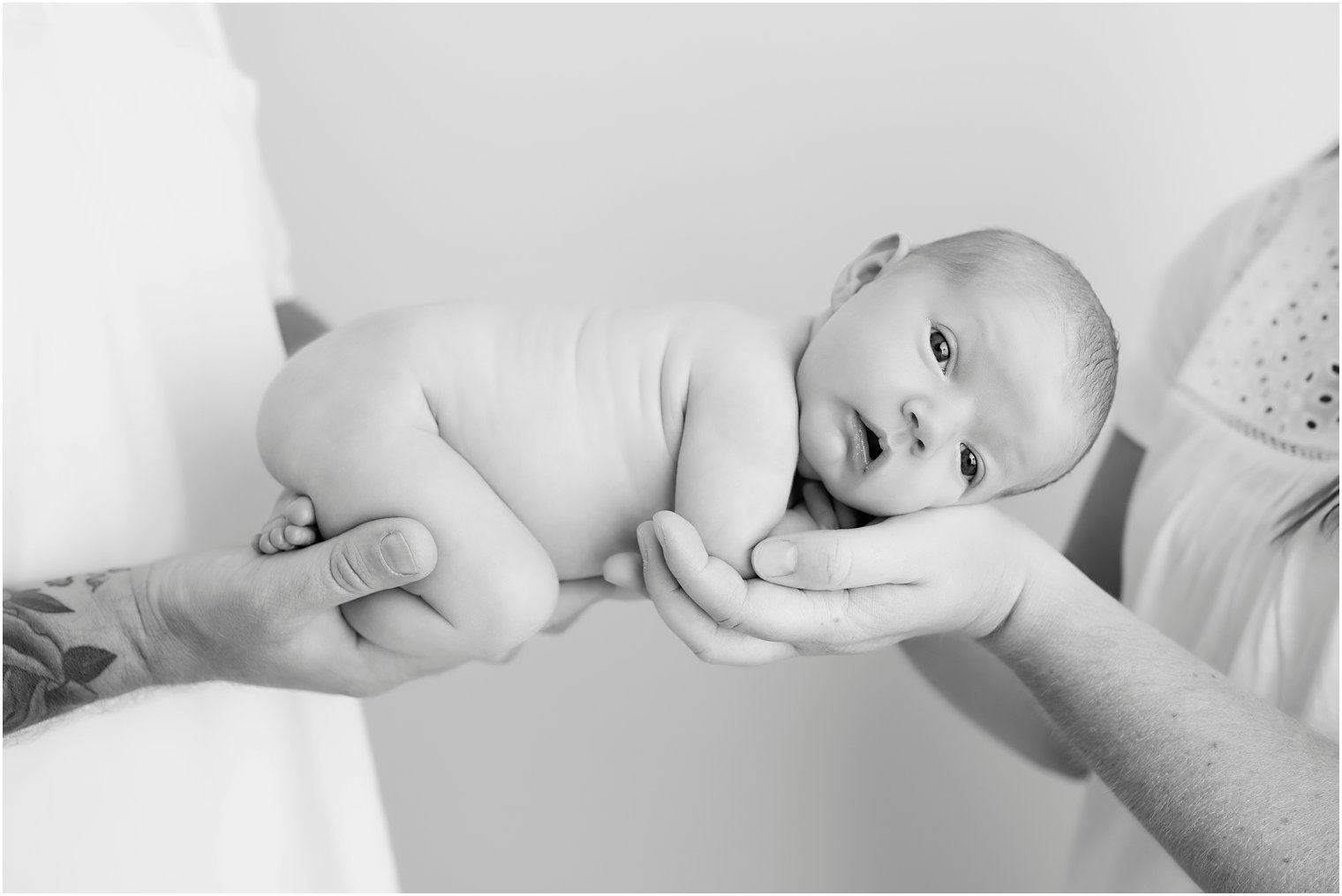 Newborn girl in parents' arms