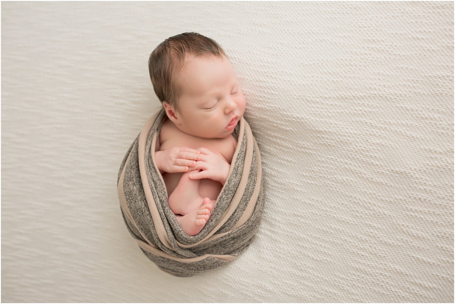 Newborn boy swaddled for newborn photos