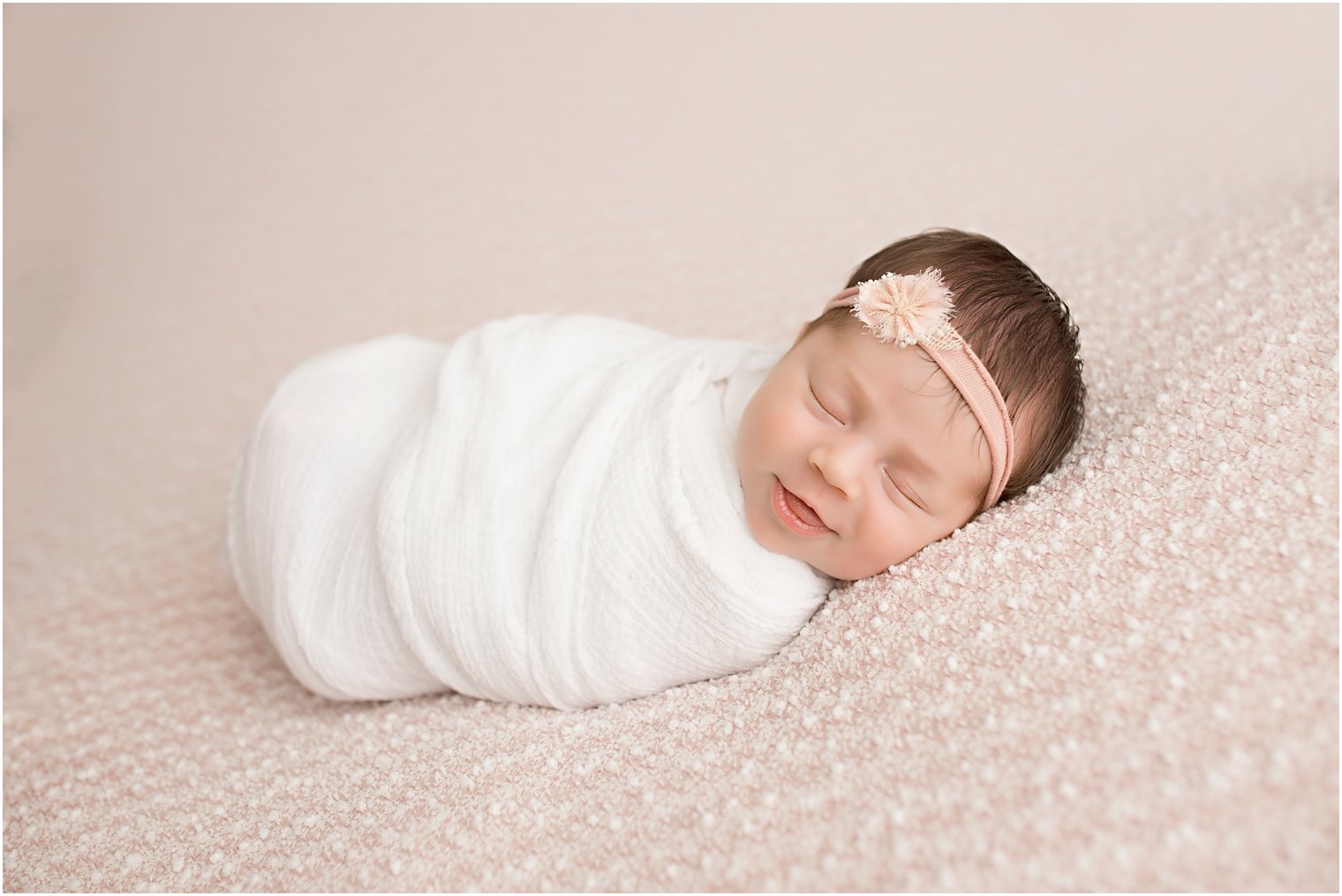 Newborn baby smiling while she sleeps
