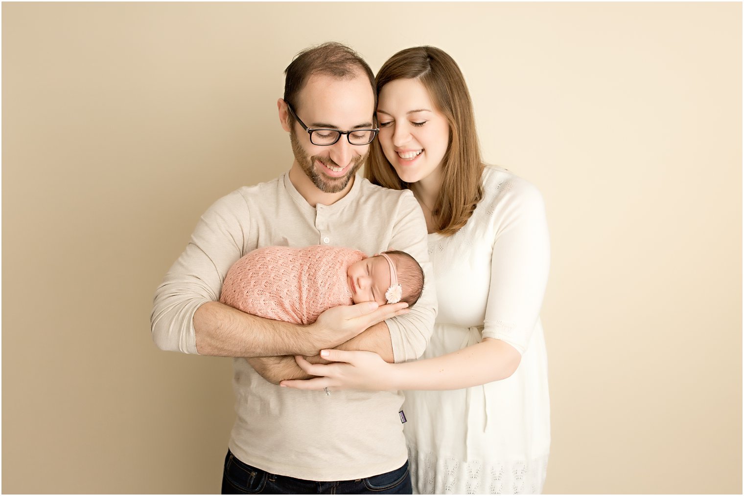 Parents holding baby during newborn sessionl