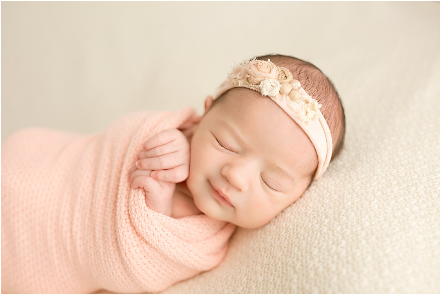 Newborn girl in salmon pink wrap and headband