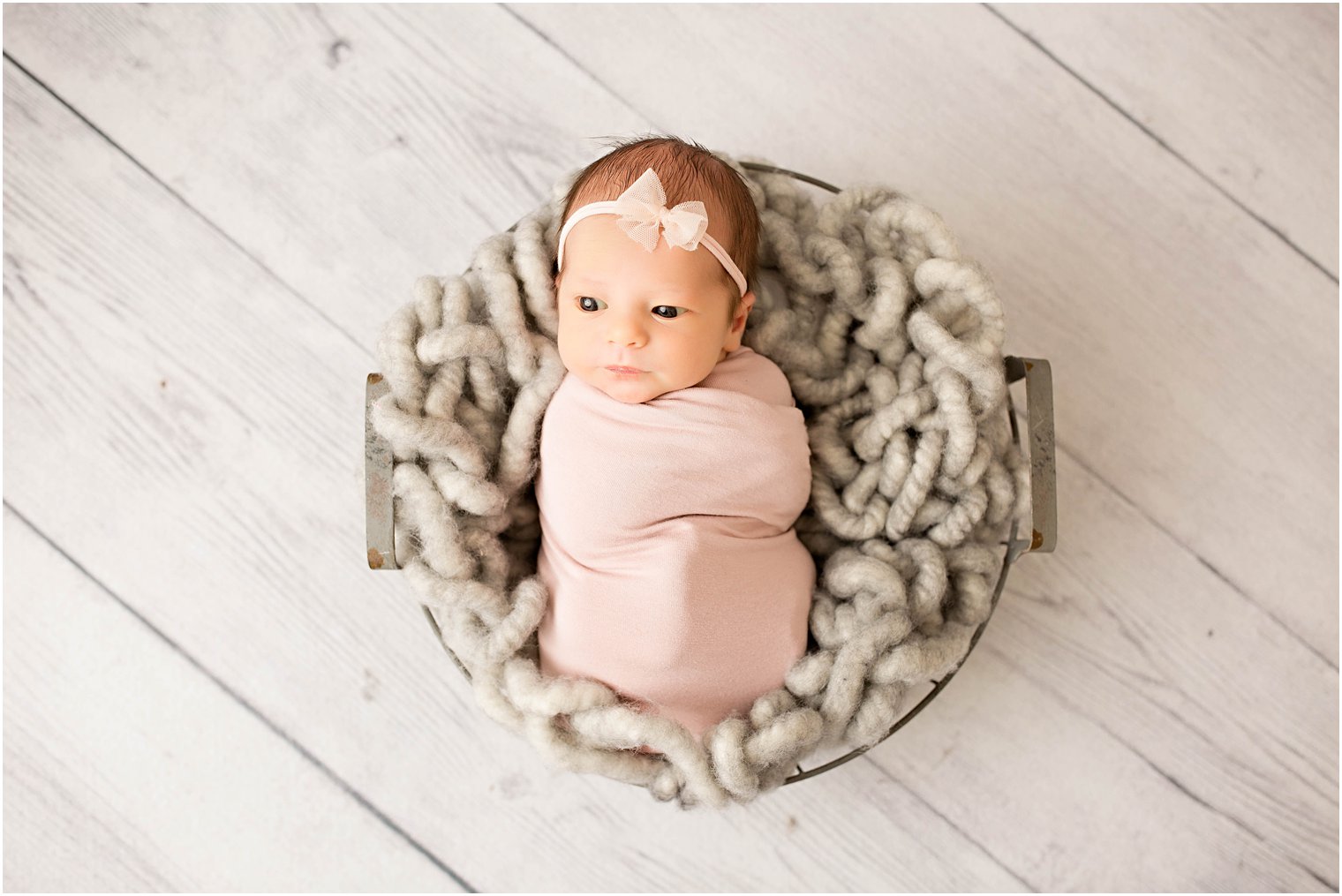 Newborn girl sleeping in a wire basket