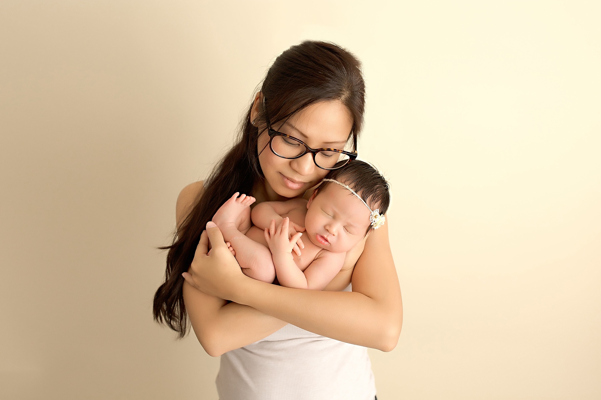 mother holding newborn baby girl in studio session
