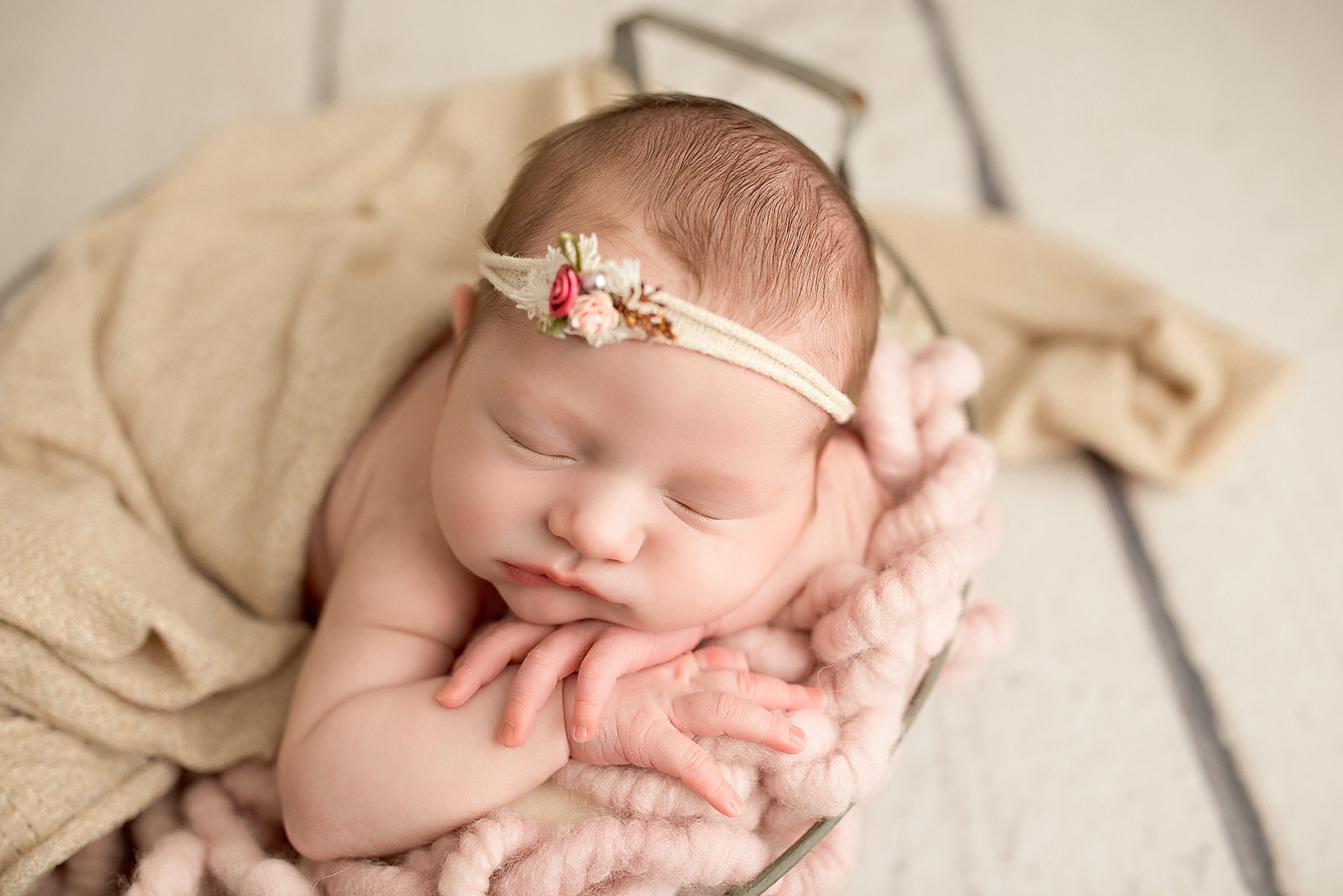 newborn baby girl with pink and tan details during newborn session