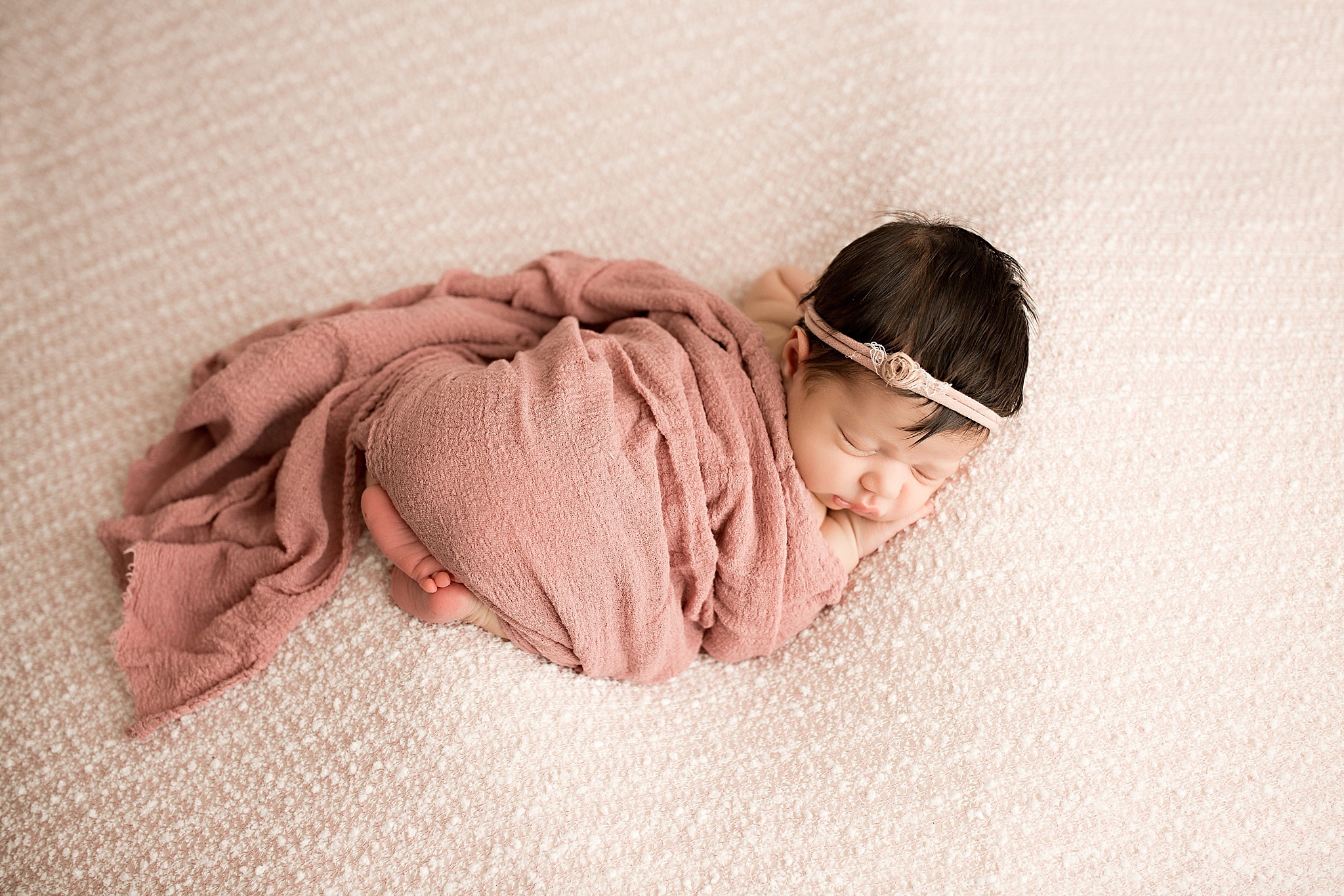 newborn baby girl in dusty rose pink wrap