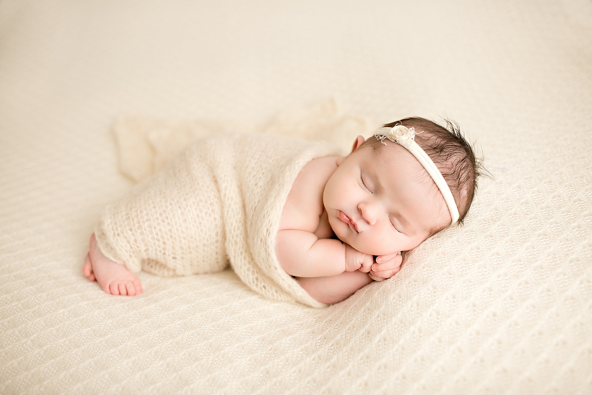 baby girl sleeping in neutral ivory set up 