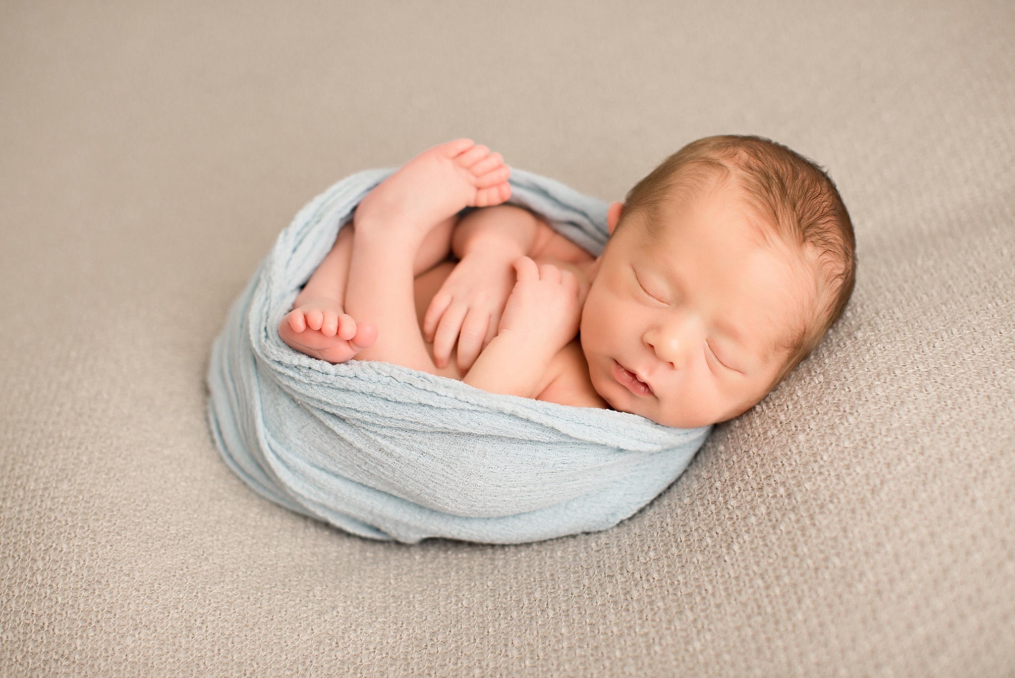 baby boy curled up in wrap during NJ newborn session 