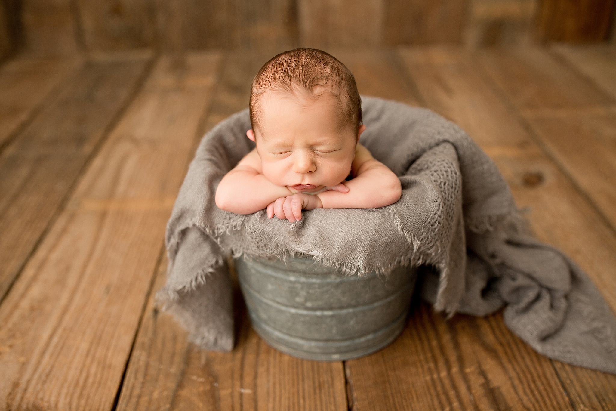 baby sleeping in bucket during newborn session