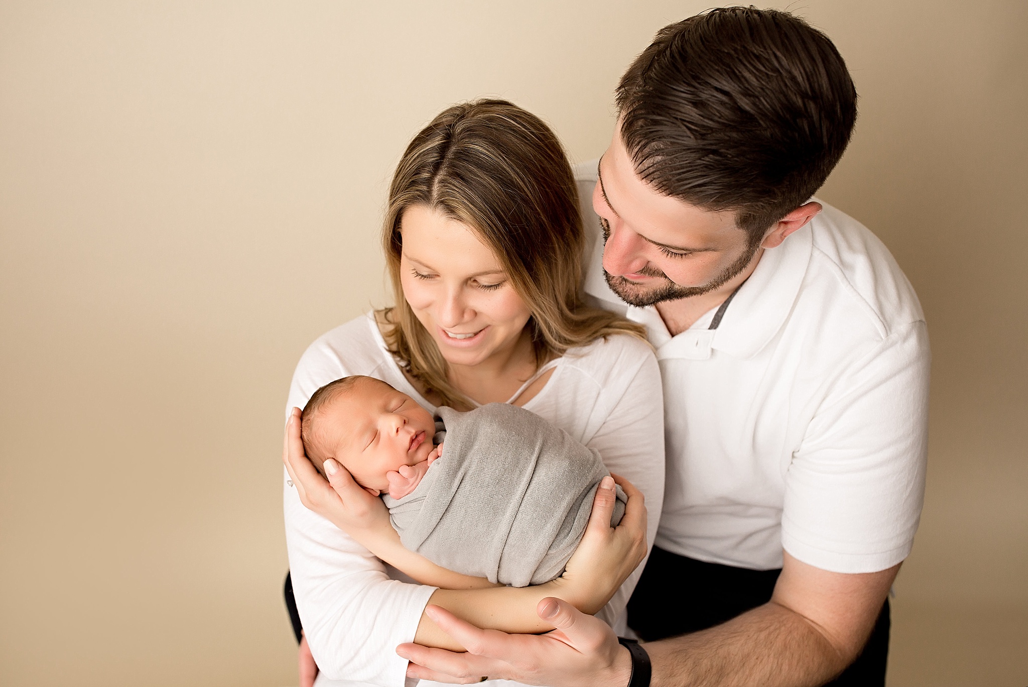 new parents holding baby boy during newborn session