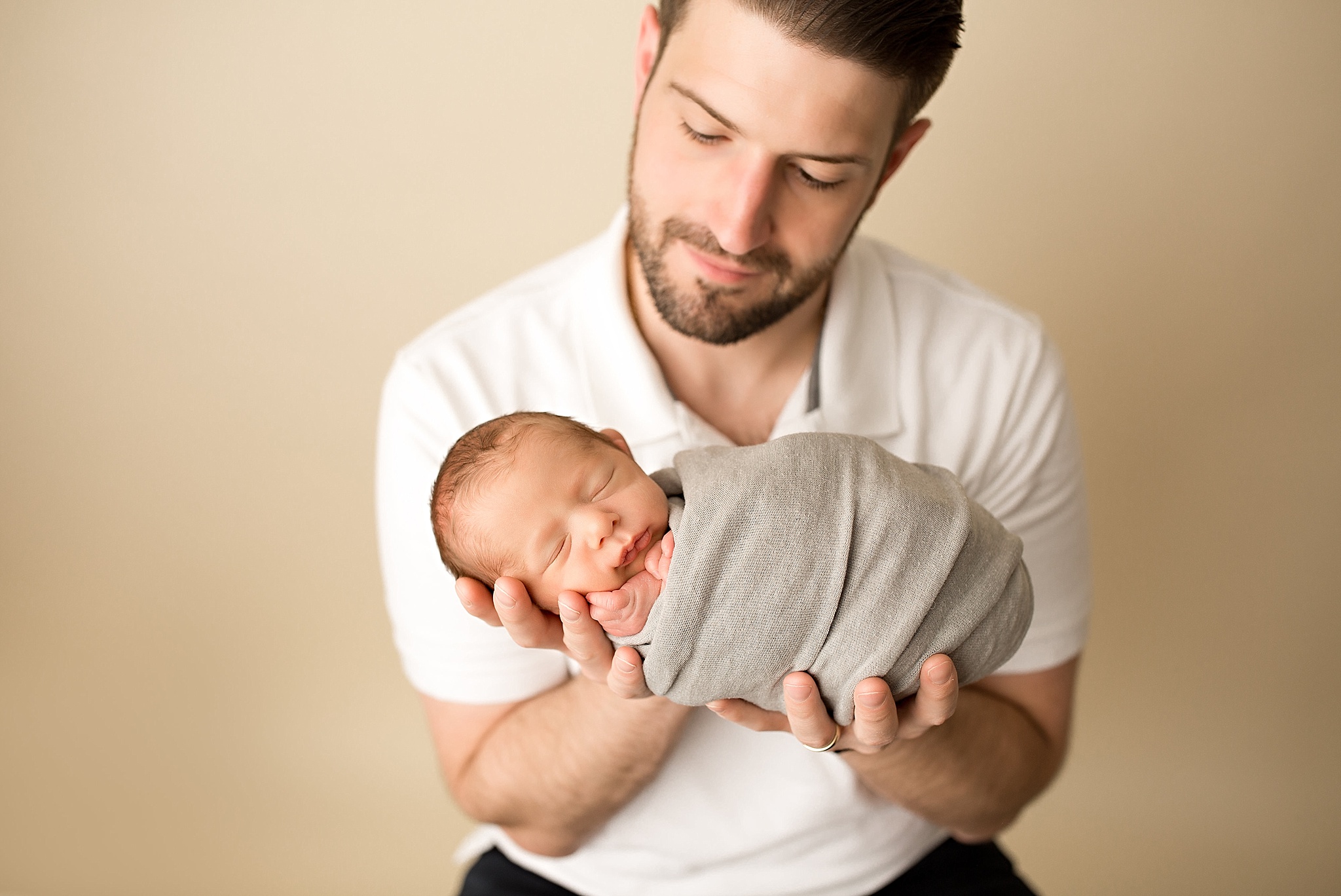 dad cradling baby boy during newborn session