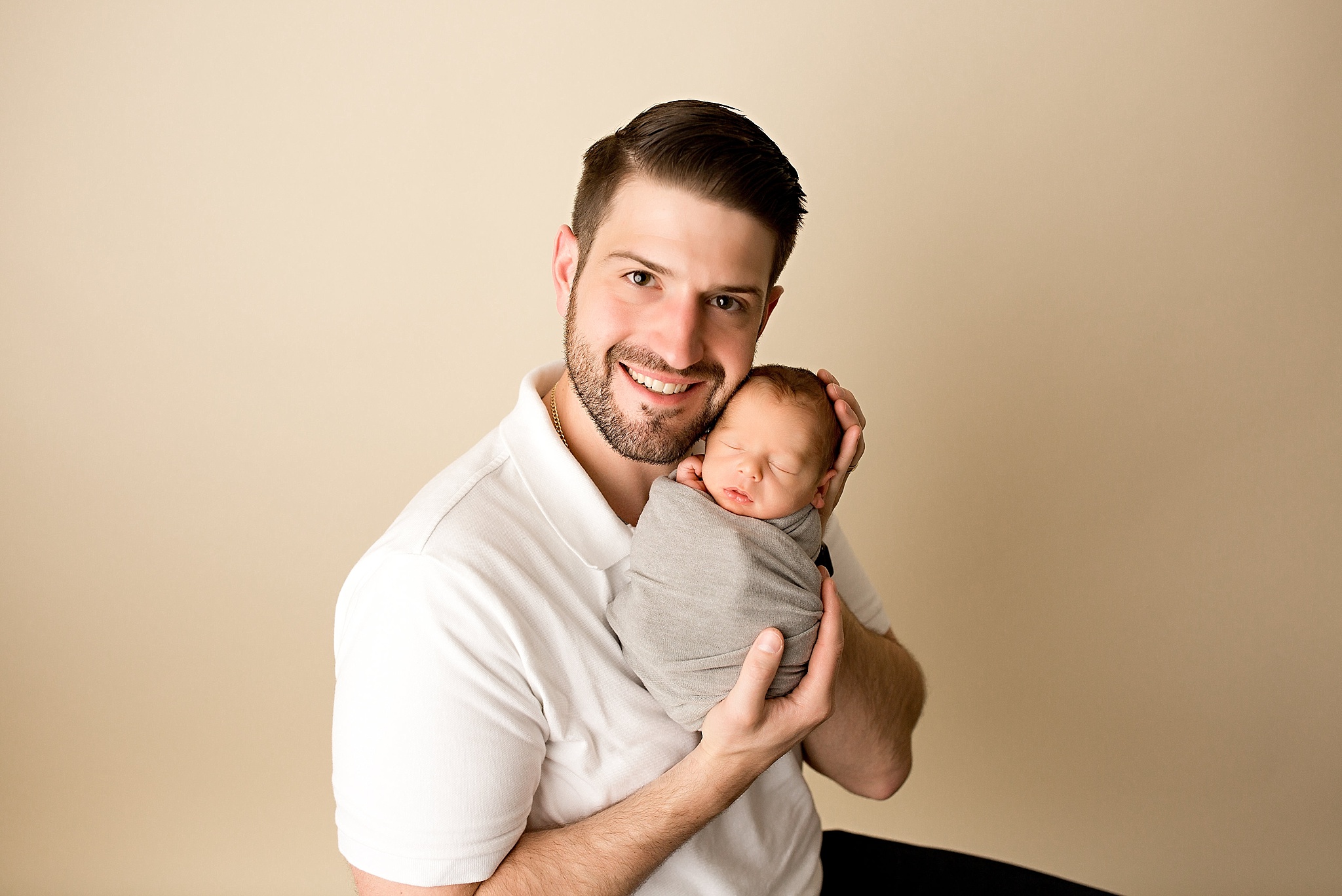 proud dad showing off baby boy during newborn session