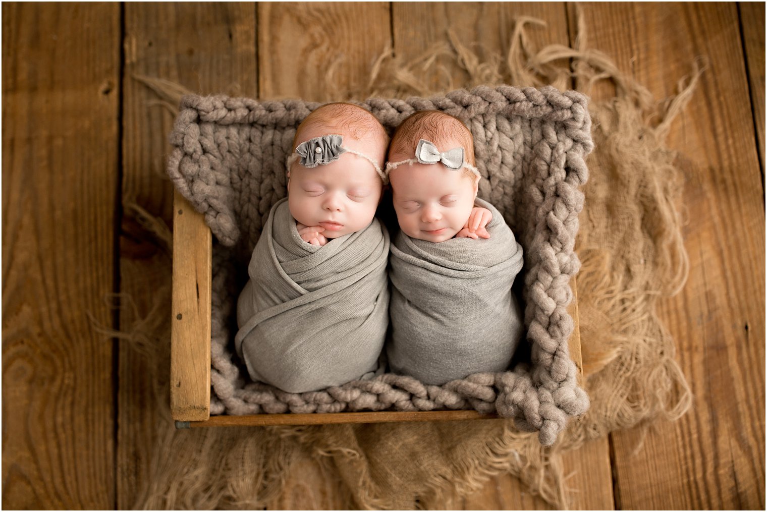 newborn triplet sisters in a crate