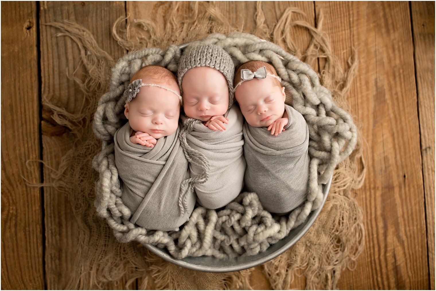 Triplets posed in a bucket