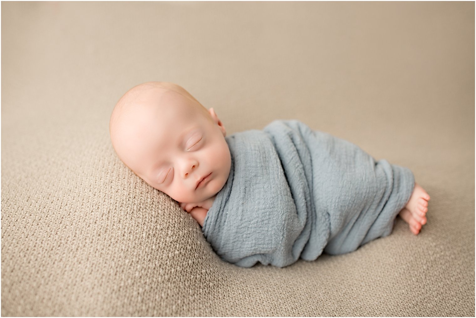 Newborn boy in side lying pose