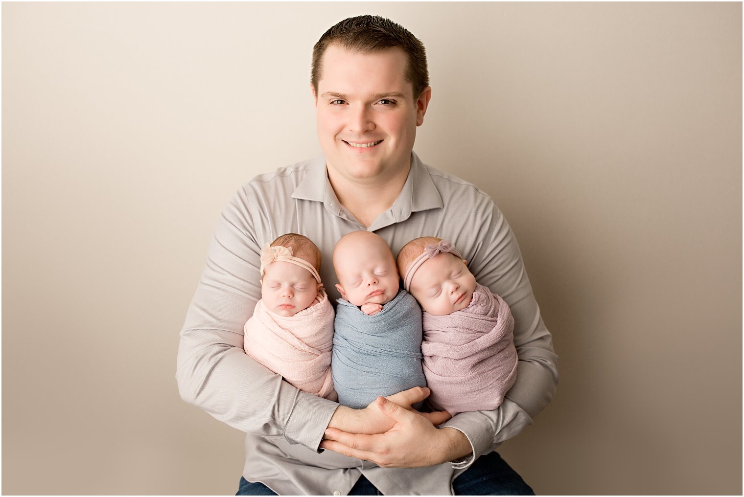 Father holding triplet babies