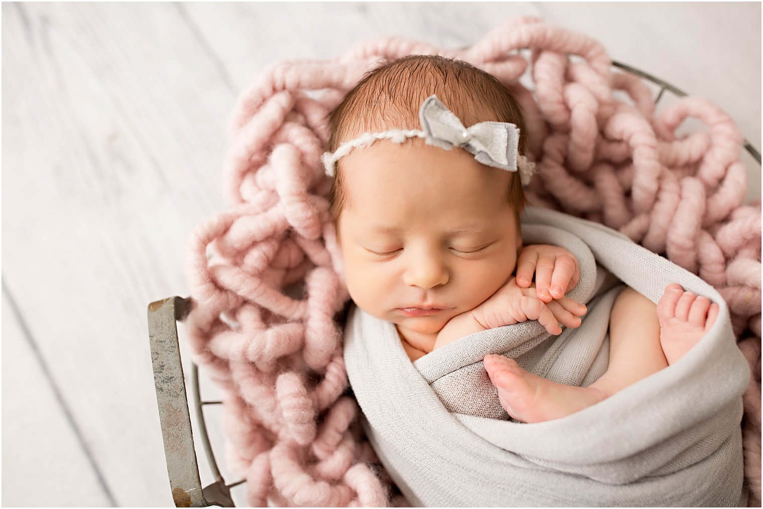 newborn girl in pink and gray setup
