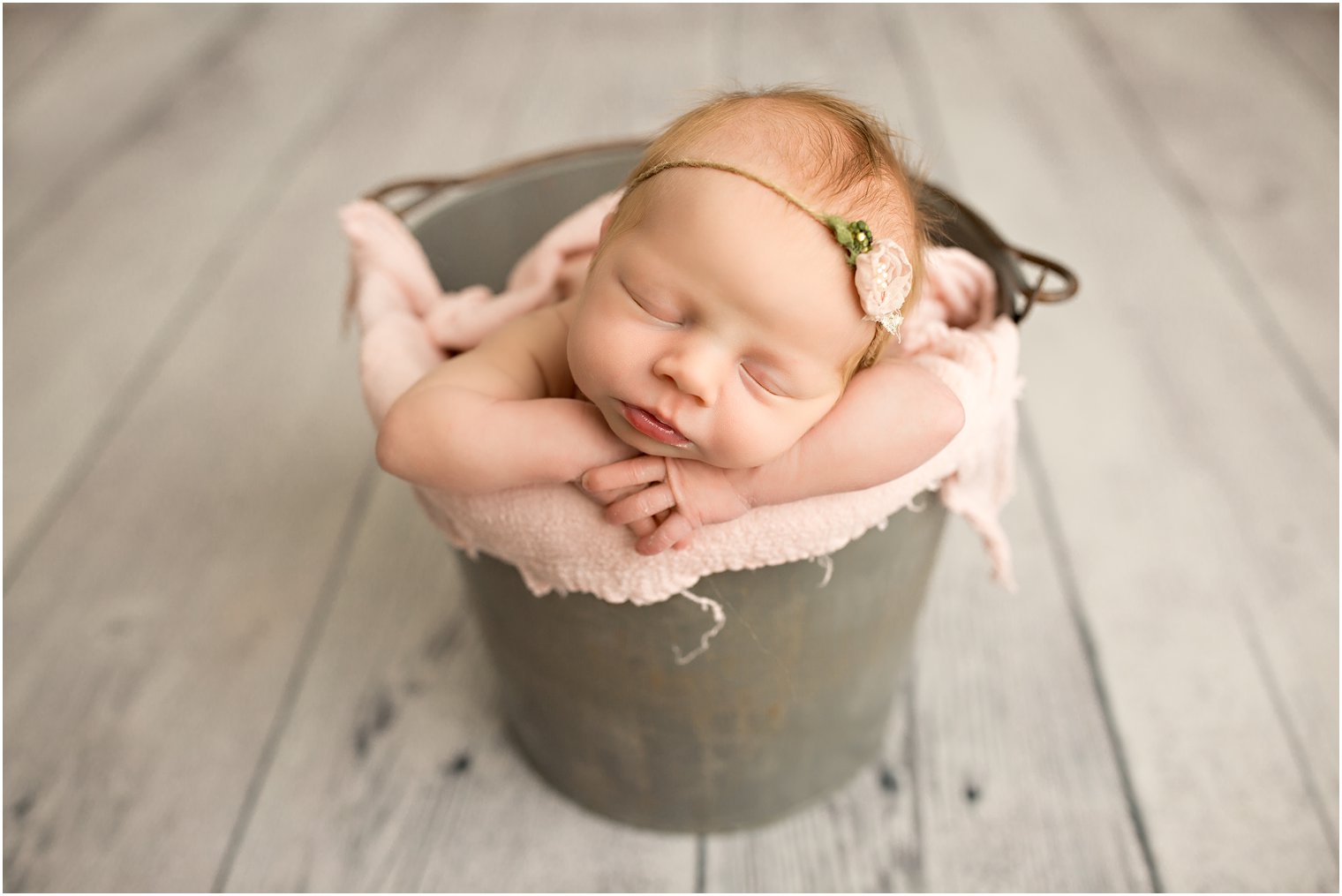 newborn baby girl in a gray bucket