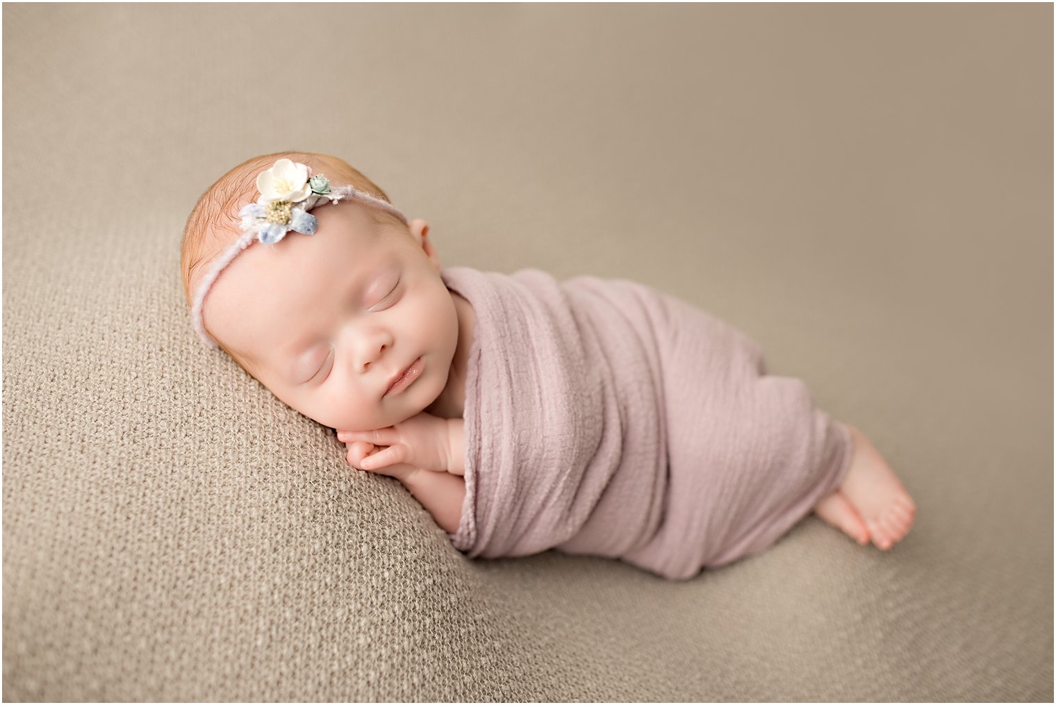 newborn girl wearing lavender wrap
