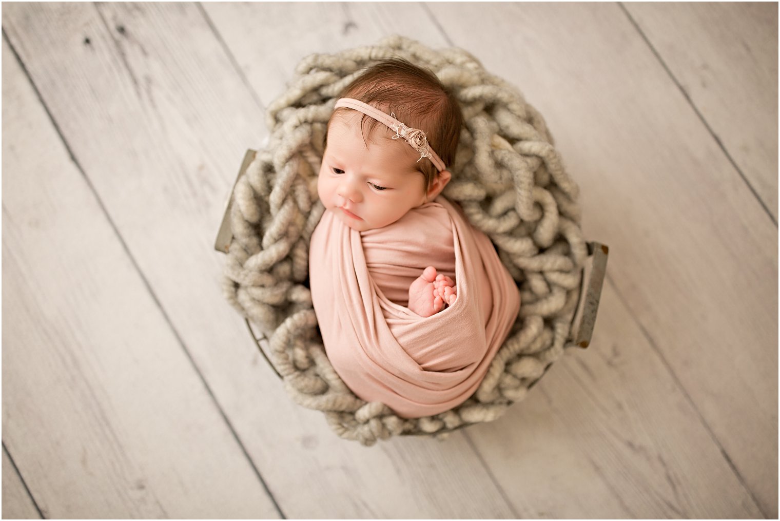 newborn girl in a wire basket