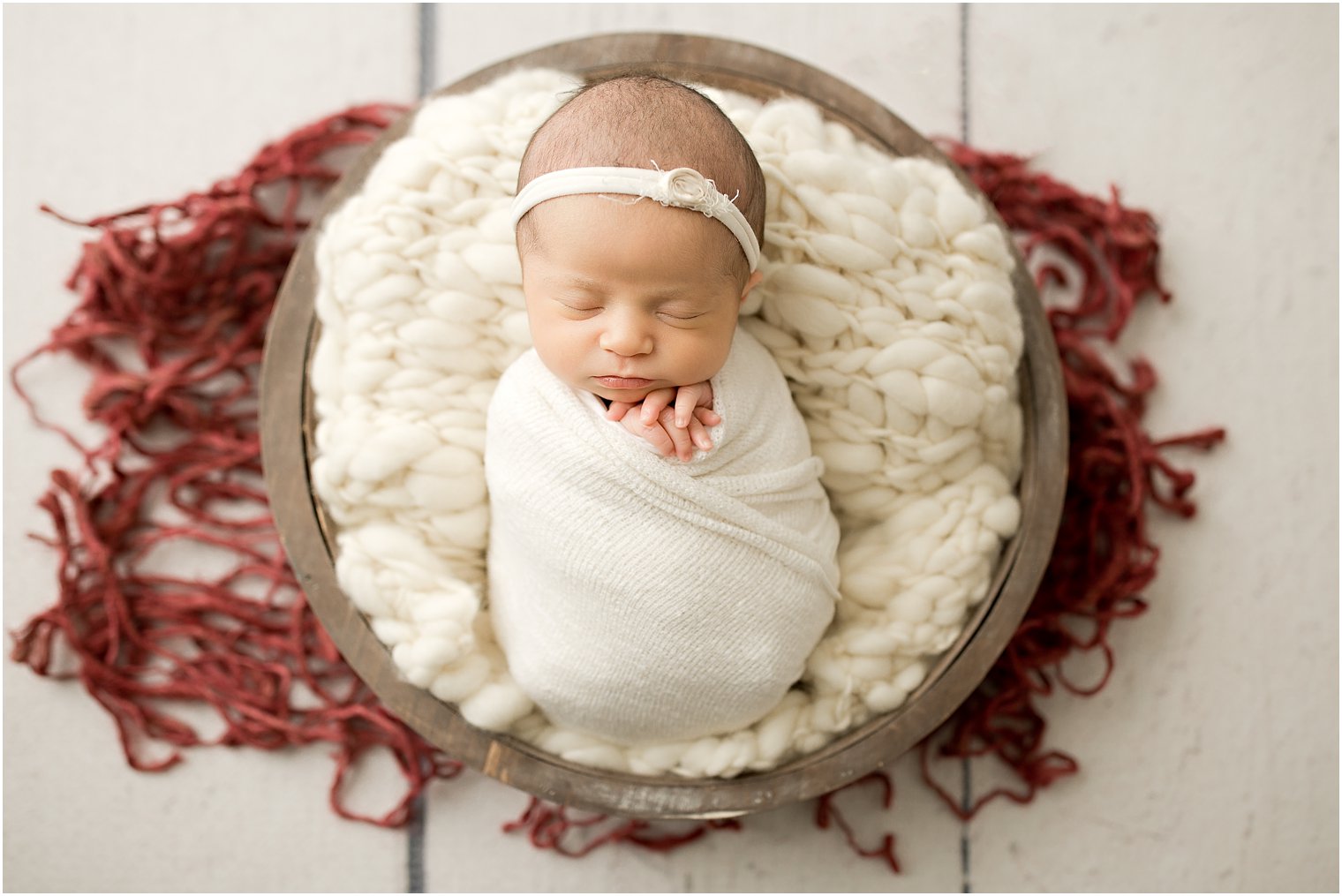 newborn girl sleeping in wooden bowl