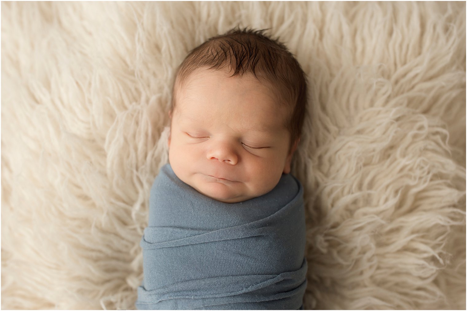 newborn boy sleeping on a fuzzy blanket