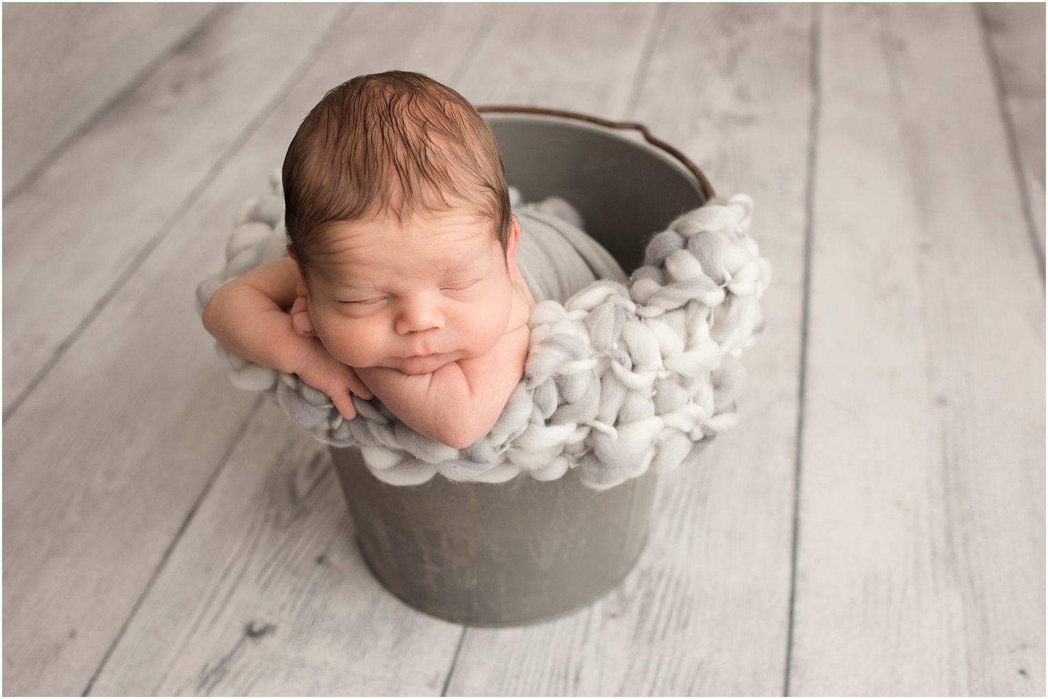 newborn boy in a blanket and bucket