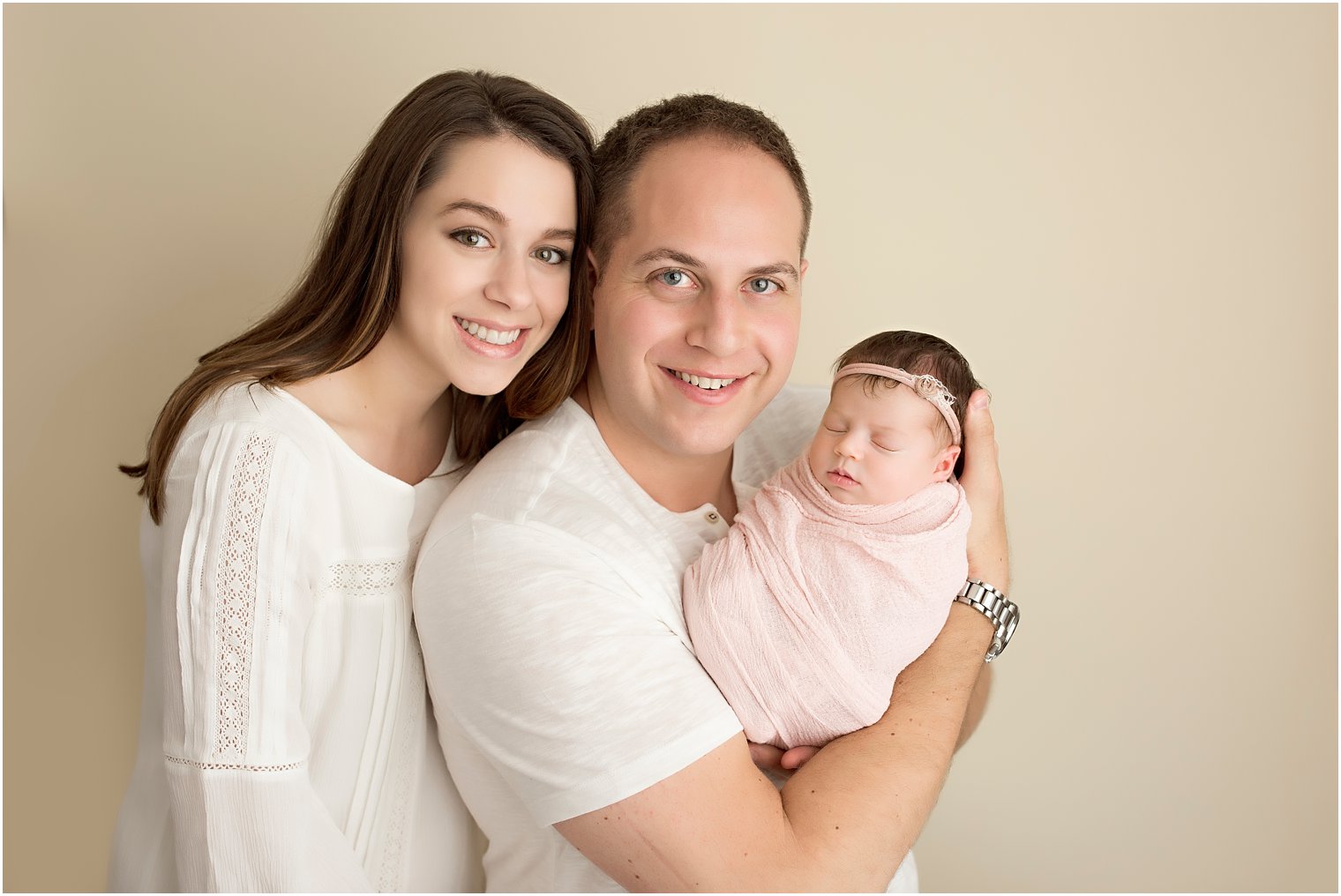 Newborn girl with her two parents in studio newborn session