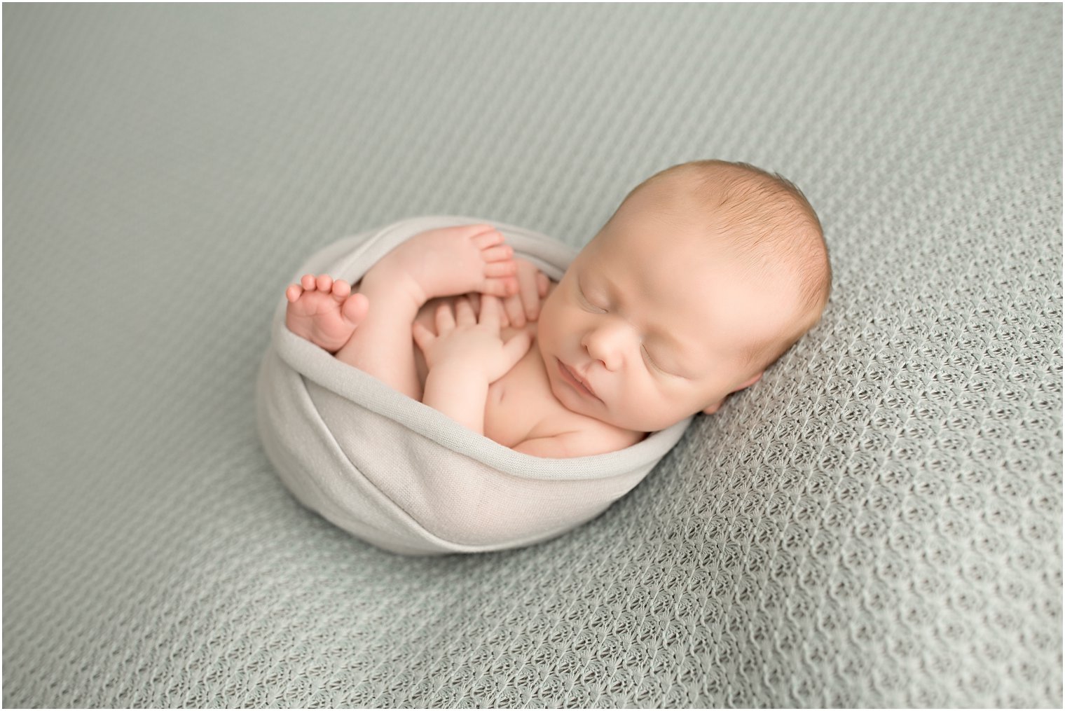 Newborn boy in gray and soft blue