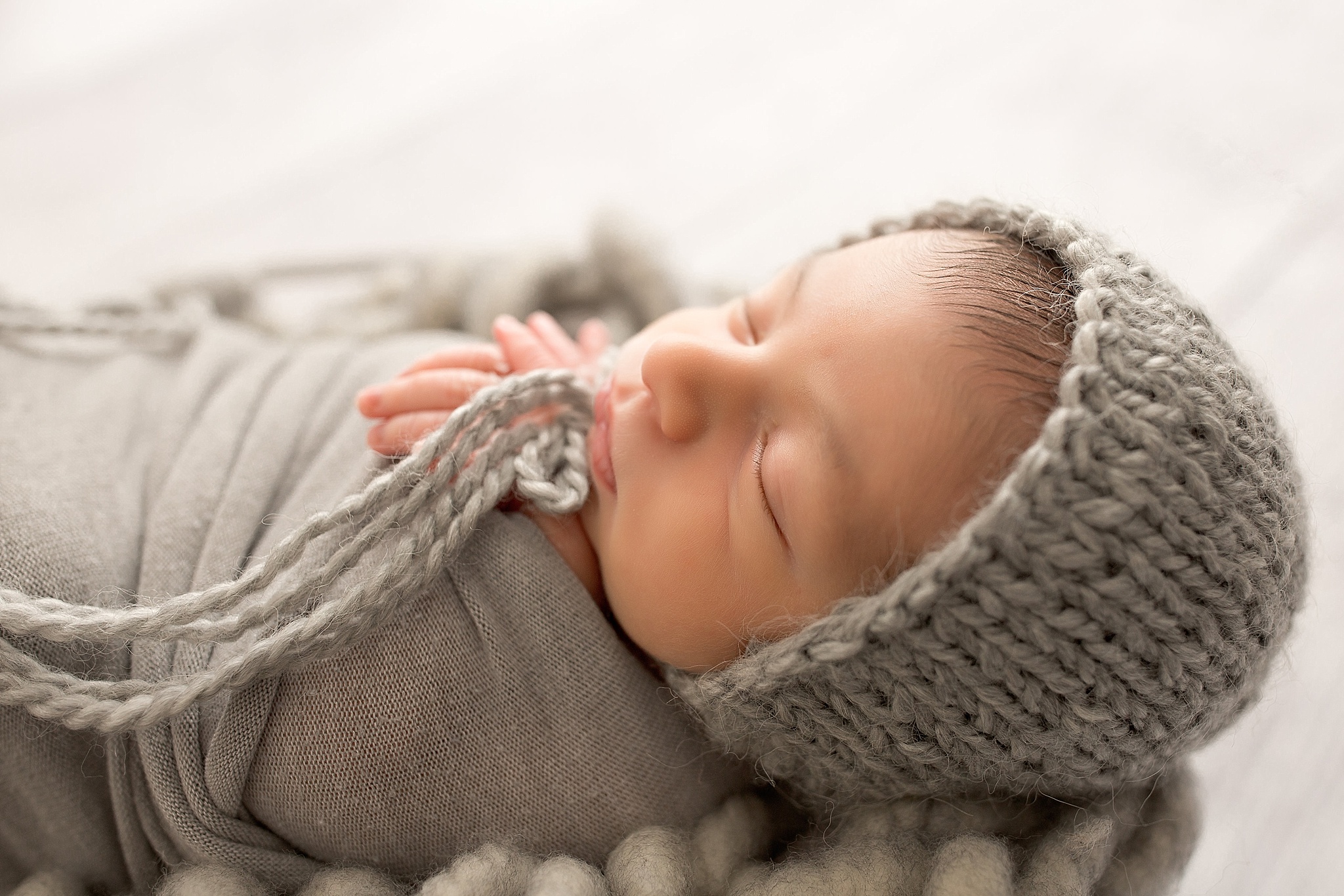baby boy sleeping in grey knit cap