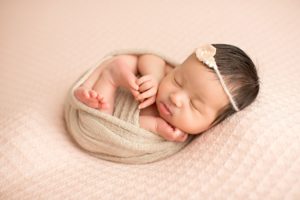 newborn baby girl wrapped up with headband