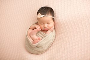 baby girl in tan wrap newborn picture