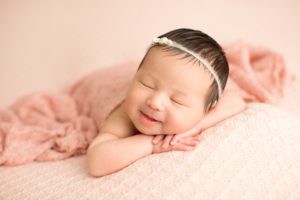 baby girl newborn smile with pink wrap